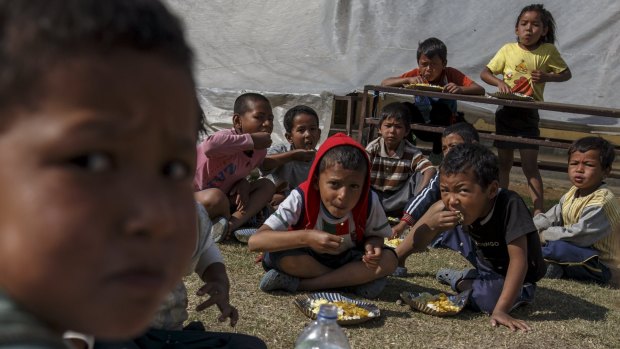 Earthquake survivors eat breakfast in a makeshift shelter in Sankhu, on the outskirts of Kathmandu, on Tuesday.