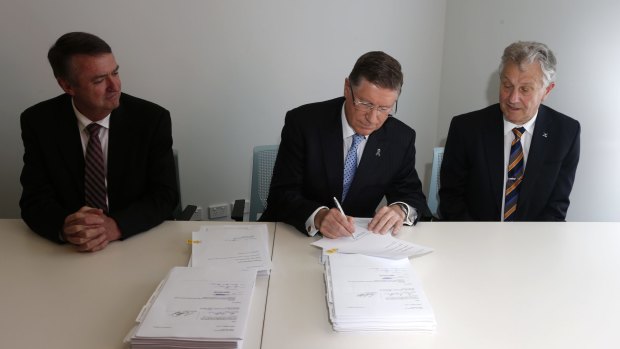 Denis Napthine, centre, signs the EWL contract with Terry Mulder and Ken Mathers.