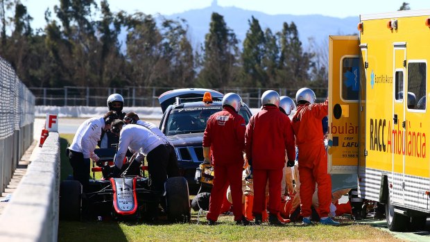 Fernando Alonso of Spain and McLaren Honda receives medical assistance after crashing in February.