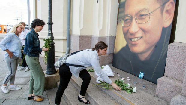 People place flowers and light candles in front of a picture of Liu Xiaobo, placed outside the Nobel's Peace centre in Oslo, on Thursday.