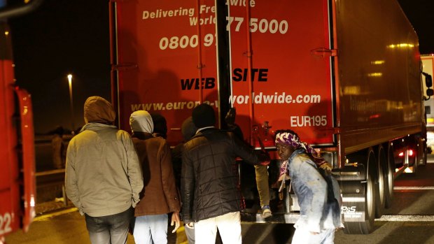Migrants open a truck in a failed attempt to cross the English Channel, in Calais on Wednesday.