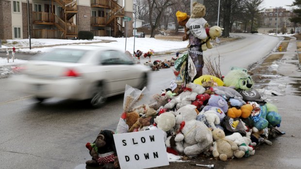 A car passes a memorial in Ferguson this week for Michael Brown, who was shot and killed by police officer Darren Wilson last year.