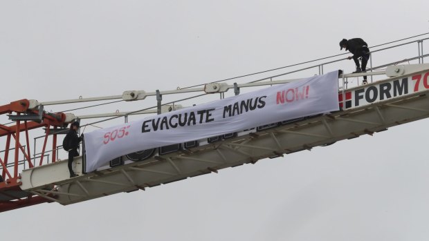 Protesters unfurl a banner on a crane at Flemington.
