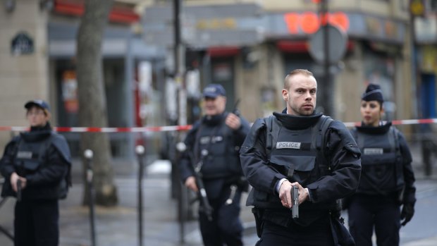 Police officers guard the scene of a fatal shooting and foiled attack that took place at a police station in Paris last week
