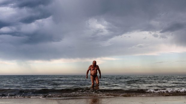 A swimmer wades through the shallows at Mentone Beach on Christmas Eve.