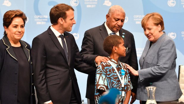 From right: German Chancellor Angela Merkel talks to Fijian Prime Minister and COP president Frank Bainimarama, and Timoci Naulusala, as France's Emamanuel Macron and the UN's Patricia Espinosa look on.