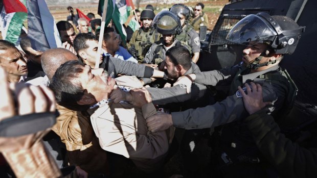 Palestinian minister Ziad Abu Ein (left) scuffles with an Israeli border policeman near the Ramallah.