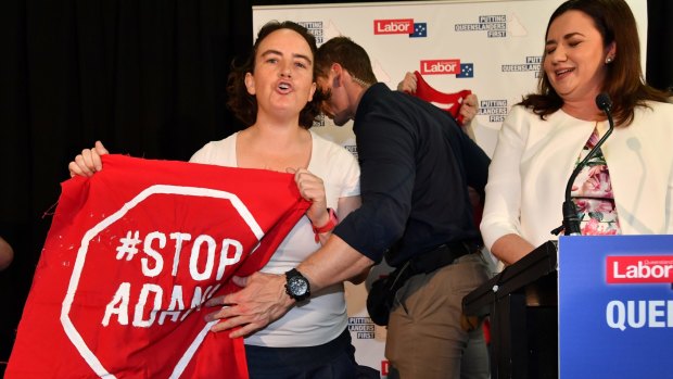 Anti-Adani coal mine protesters invade the stage as Queensland Premier Annastacia Palaszczuk (right) speaks in Brisbane on Sunday.