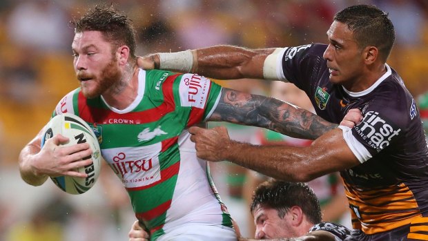 On the charge: Chris McQueen holds off Justin Hodges.