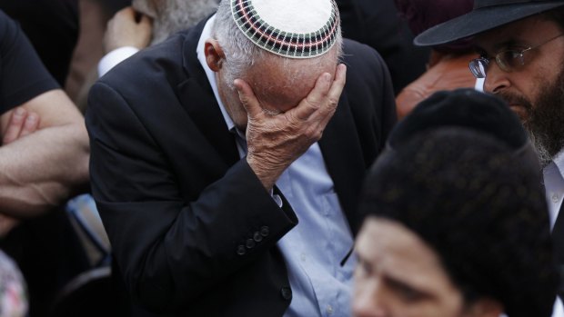 An Israeli mourns during the funeral of Aryeh Kopinsky, Kalman Levine and Avraham Goldberg in Jerusalem.