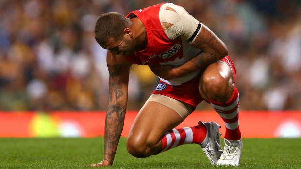 Lance Franklin holds his ribs after a bump by Shannon Hurn.