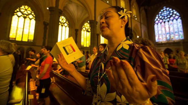 A woman prays at a mass at Melbourne's St Patrick's Cathedral in memory of the dead and wounded in Friday's Paris attacks. 