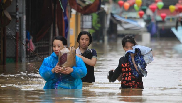 People wade through a flooded street of Hoi An ancient town, Vietnam, on Monday.