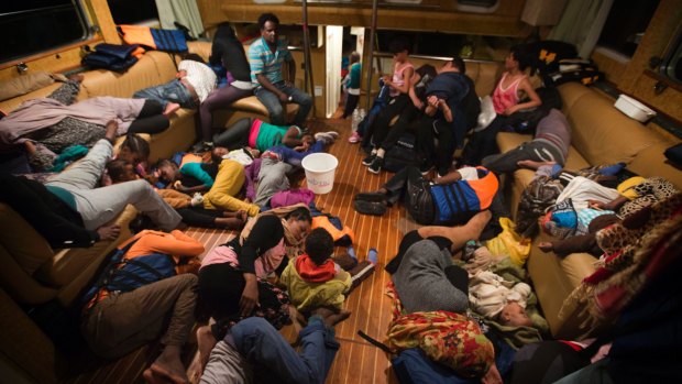 Refugees from Eritrea rest inside the Astral vessel after being rescued from the Mediterranean sea.