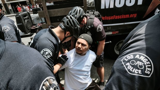 A Trump supporter is arrested by Los Angeles Police officers after getting into a fight with an anti-Trump protester in Los Angeles.