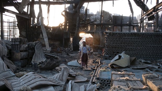 A man walks through the remains of a factory that was bombed twice in September outside Yemen's capital, Sanaa.