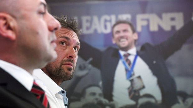 Fast move: Tony Popovic and CEO John Tsatsimas address the media to explain the coach's abrupt departure, against a backdrop showing better times.