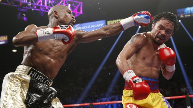 In trouble: Floyd Mayweather (left) lands a jab against Manny Pacquiao.