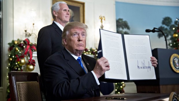 US President Donald Trump holds up the proclamation on Jerusalem next to Vice President Mike Pence last week.