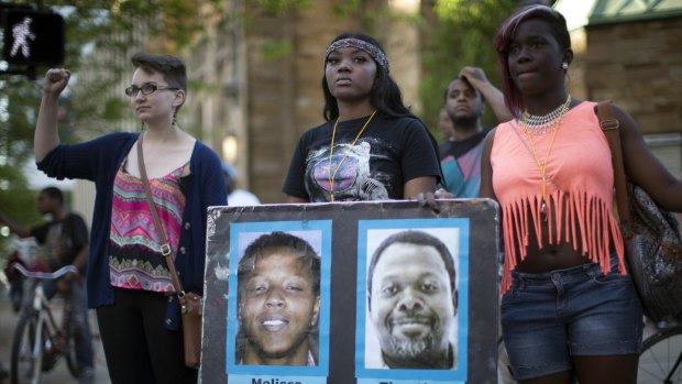 Demonstrators holding pictures of Timothy Russell and Malissa Williams protest the acquittal of Michael Brelo.