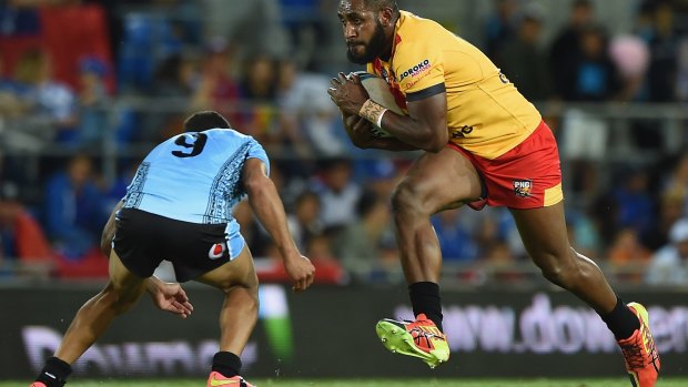 Runaway train: Wellington Albert of Papua New Guinea takes on the defence.