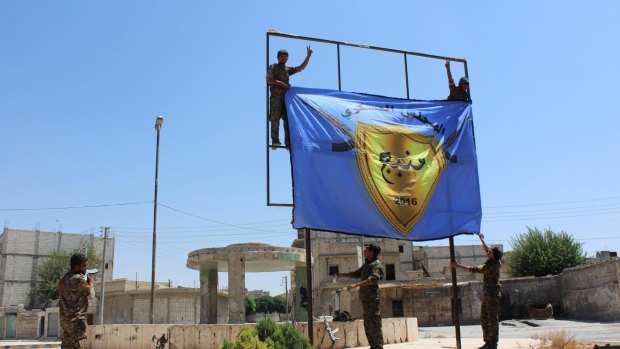 An August 8 photo released by a pro-Kurdish news agency shows   the Kurdish-led Syrian Democratic Forces raising a banner in the centre of the town of Manbij. That success may have provoked the Turkish incursion into Syria at Jarablus.