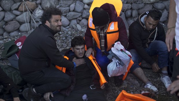 Palestinian doctor Essam Daoud, left, cares for Syrian refugees after their arrival on the Greek island of Lesbos. 
