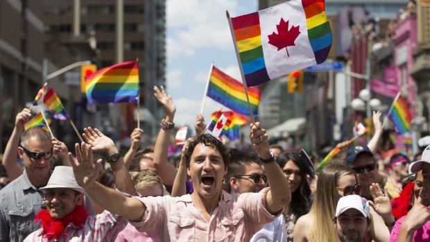Prime Minister Justin Trudeau waves a flag as he takes part in the annual Pride Parade in Toronto on Sunday.