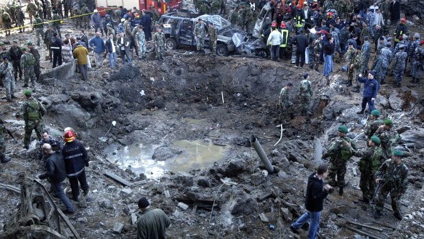 Rescue workers stand around a massive crater after a bomb attack that  killed Lebanese leader  Rafiq Hariri in Beirut on February 14, 2005.