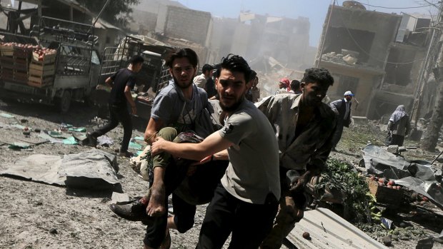 Men transport a casualty after the air strikes on a busy marketplace in Douma.