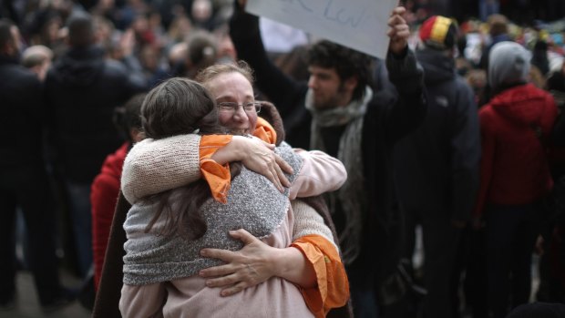 People embrace at the Place De La Bourse in Brussels in honour of the victims of the terrorist attacks.