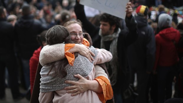 People embrace at the Place De La Bourse in Brussels in honour of the victims of the terrorist attacks.