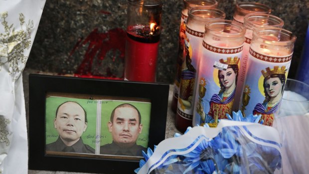 Photographs of slain police officers Wenjian Liu and Rafael Ramos are placed in a makeshift memorial in Brooklyn.