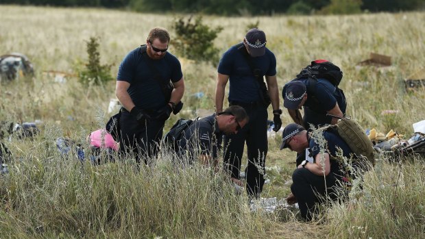 Australian Federal Police officers and their Dutch counterparts collect human remains from the MH17 crash site in the fields outside the village of Grabovka.