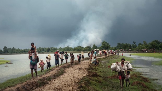 Rohingya refugees near the Naf River separating Myanmar and Bangladesh in September, as villages in Myanmar are set ablaze, allegedly by Myanmar's military.