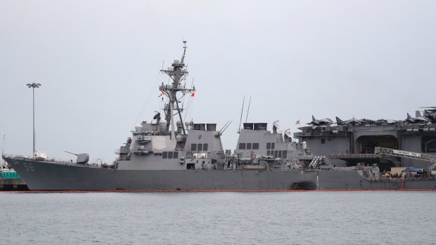 The damaged port aft hull of USS John S. McCain, left, is seen while docked next to USS America at Singapore's Changi naval base.