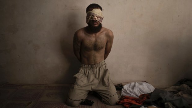 A suspected Islamic State fighter sits in a basement as Iraqi forces advanced on Mosul in July.