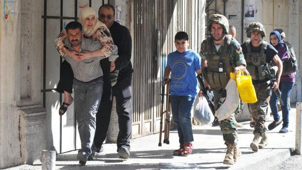 Lebanese soldiers evacuate civilians during clashes in the historic market of Tripoli on Saturday. 