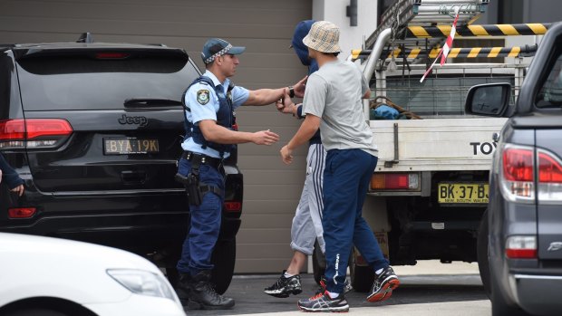 Two men try to get into a home during a raid in Merrylands.