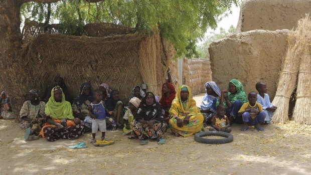 Women who lived through Boko Haram occupation sit under a tree in Damasak.