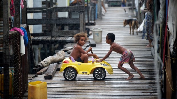 Children play on the boardwalks at Hanuabada on the outskirts of Port Moresby.