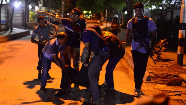 An injured man receives help after an attack at a Dhaka restaurant.