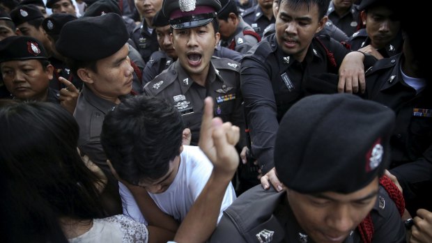 Policemen face protesters during a protest in central Bangkok on Friday.