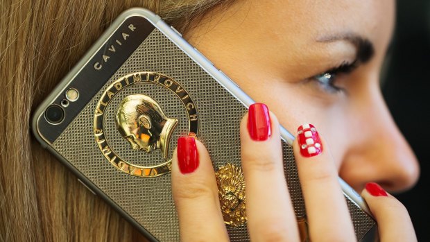 A profile of Vladimir Putin appears above the coat of arms of Russia on the casing of an 18 carat gold-plated "Ti Gold Supremo Putin" bespoke iPhone 6s, one of many items adding to the leader's personality cult.
