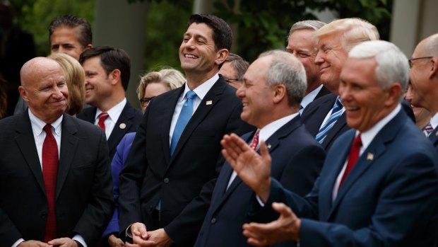 US President Donald Trump with fellow Republicans after passing their healthcare bill. 