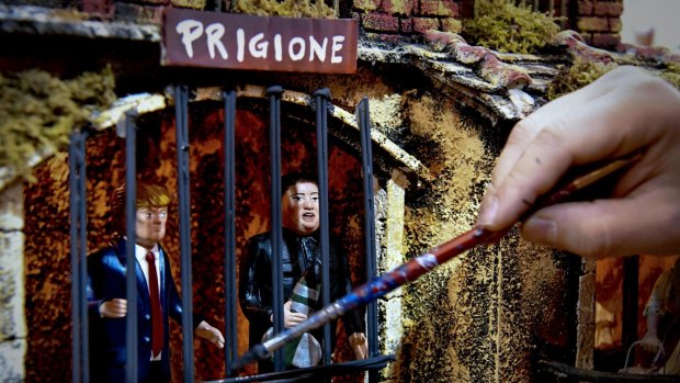 A Neapolitan artisan gives the finishing touches to a nativity scene featuring statuettes of US President Donald Trump and North Korean leader Kim Jong-un, both placed in prison, in his shop in Naples, Italy.
