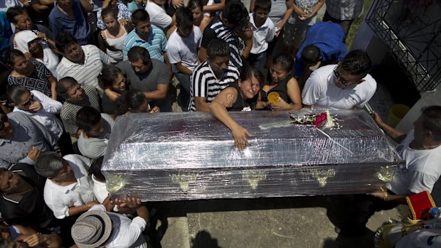 Relatives cry over the coffin of of woman who died with her mother and her brother in the earthquake, in Montecristi, Ecuador.