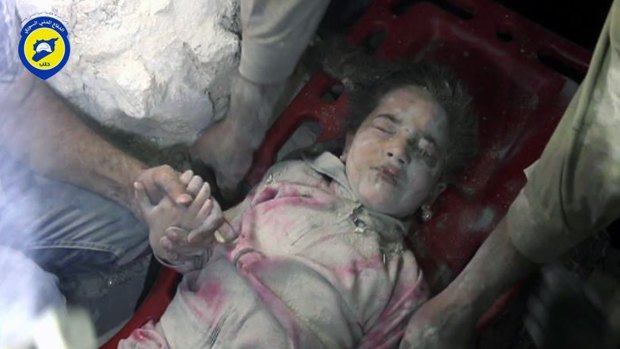 A child survivor carried from rubble in Aleppo.