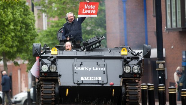 Darren Adamson, a "Vote Leave" campaigner in the northern English city of Sunderland, holds a placard as he rides in a modified armoured personnel carrier.