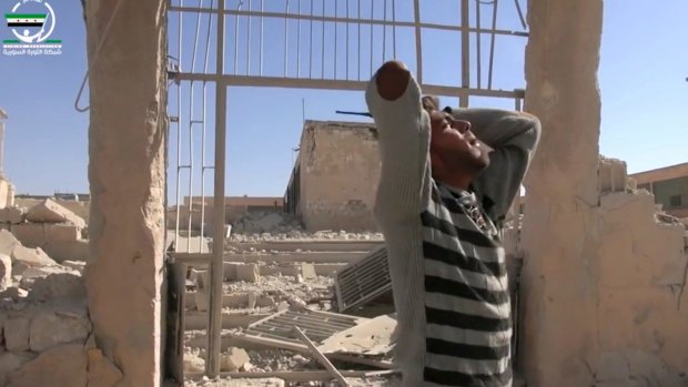 A man wails in front of destroyed buildings after airstrikes killed more than 20 people, in the northern rebel-held village of Hass, Syria, on Wednesday.